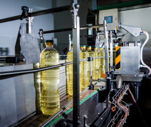 Bottling line of sunflower oil in bottles. Vegetable oil production plant. High technology. Industrial background